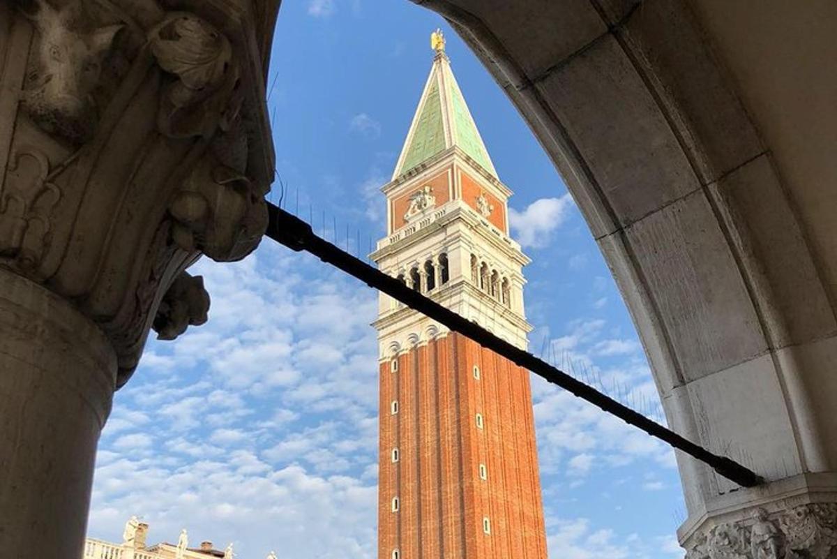 uma torre de relógio alta com um campanário atrás de um edifício