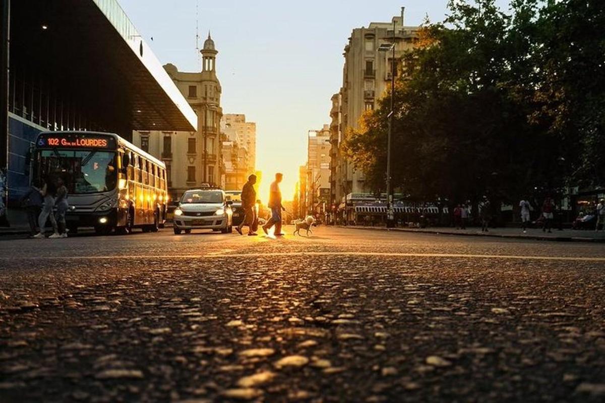 una strada cittadina con un autobus e persone che attraversano la strada