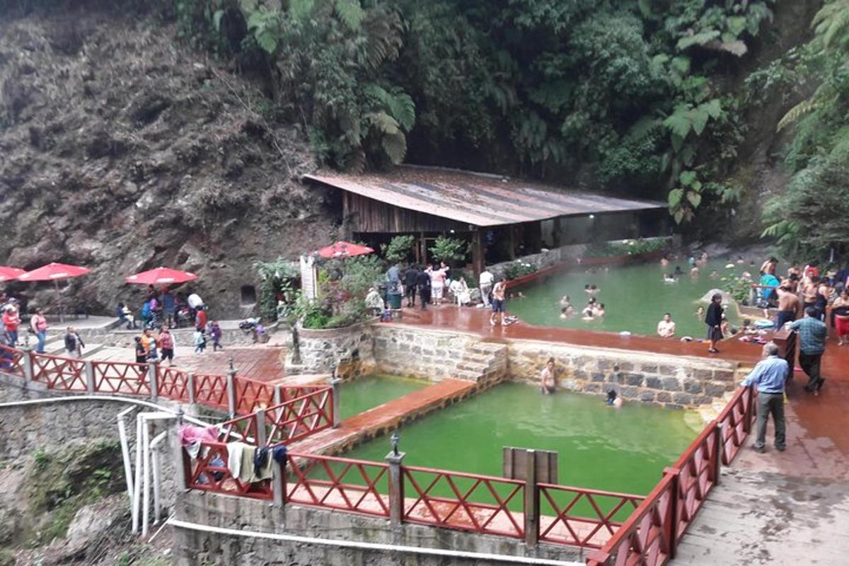 a group of people standing around a pool of green water