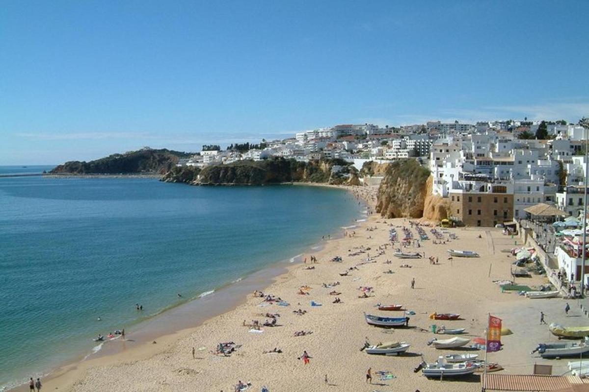 una spiaggia con un sacco di gente e barche