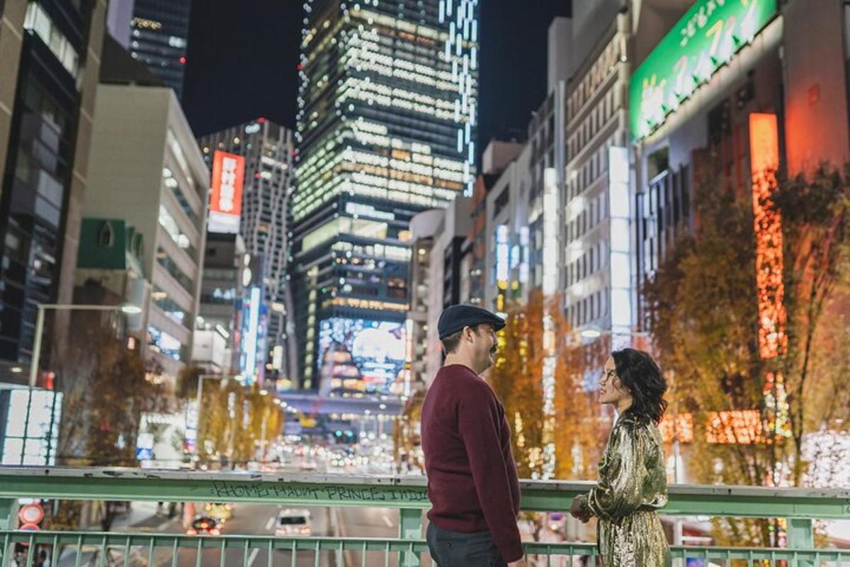 Un hombre y una mujer de pie en una ciudad por la noche.
