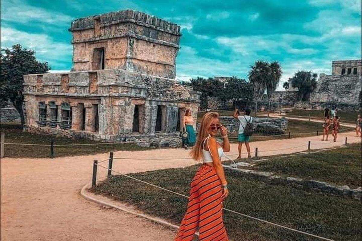 a woman in a dress standing in front of a building