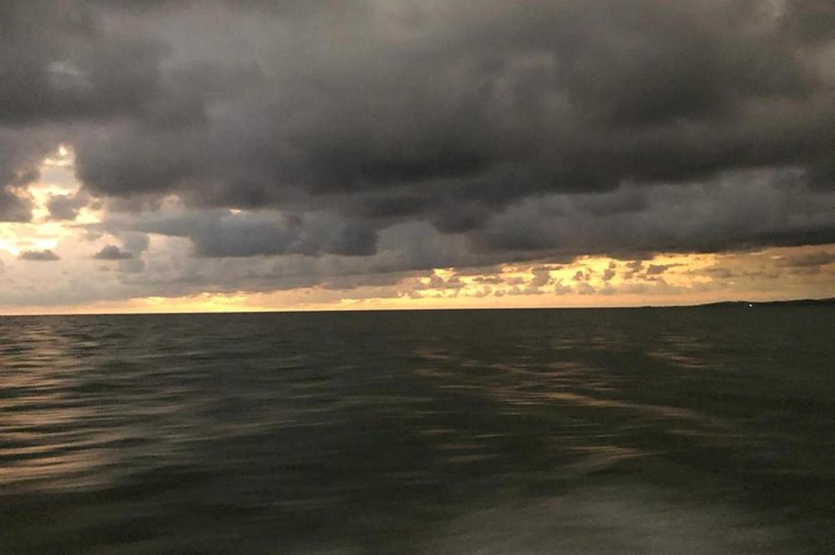 a cloudy sky over the ocean with the water