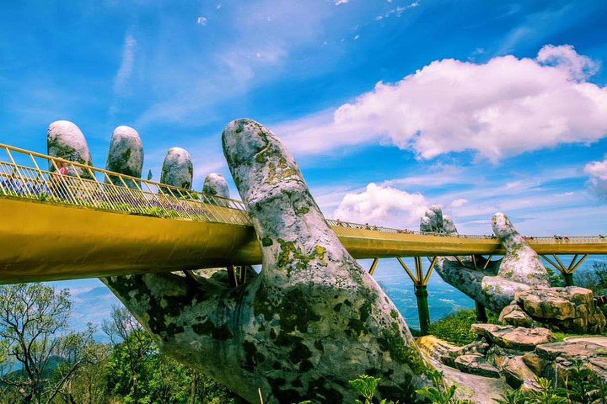 una estàtua d'una mà amb un pont al fons