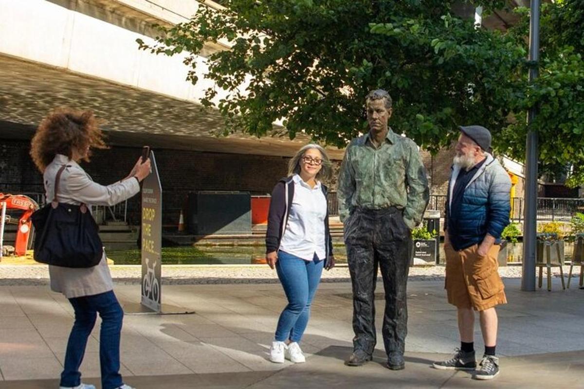 una donna che scatta una foto alla statua di un uomo