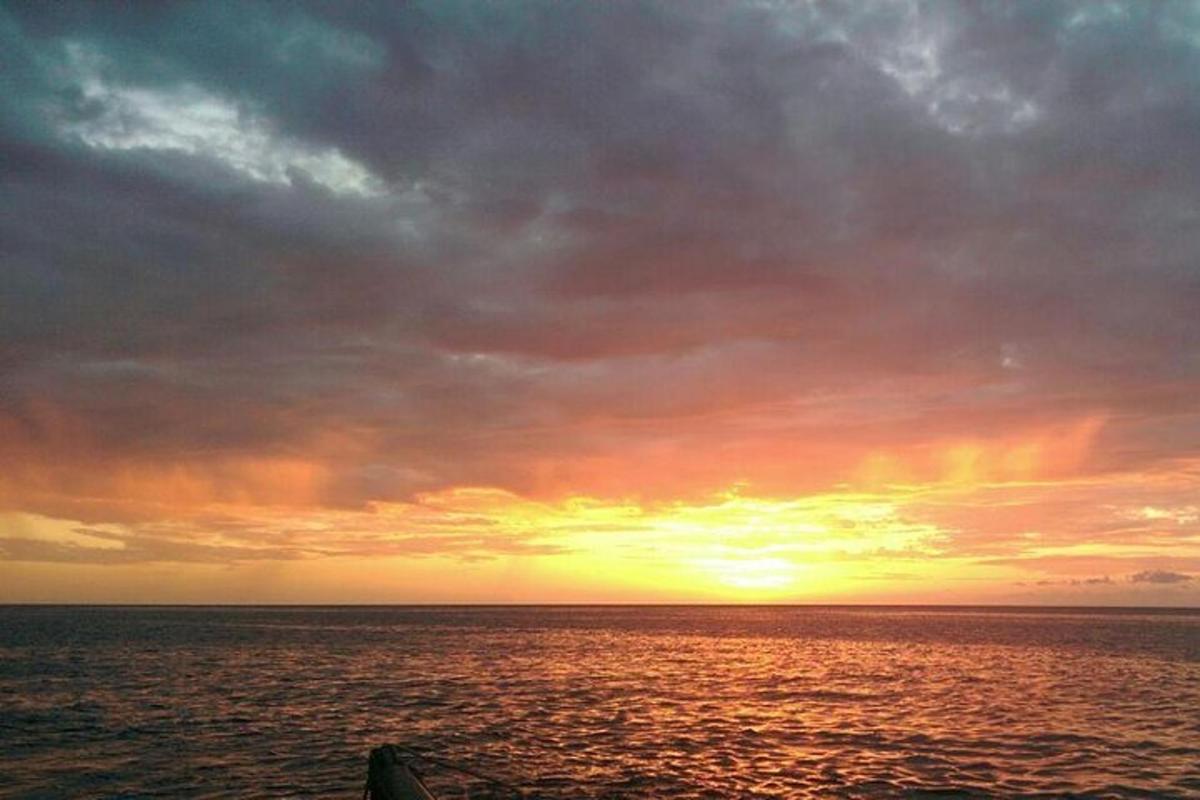 Západ slunce nad oceánem se zataženou oblohou