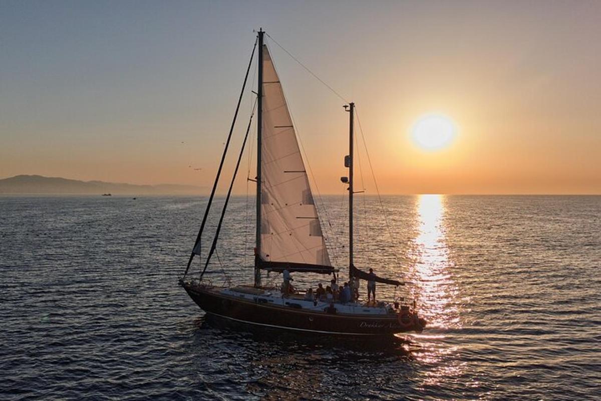 una barca a vela in acqua al tramonto