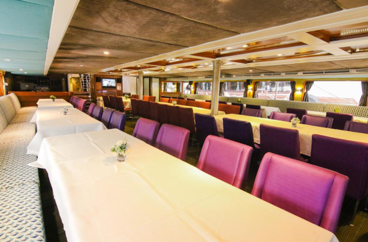 Un comedor con mesas blancas y sillas moradas.