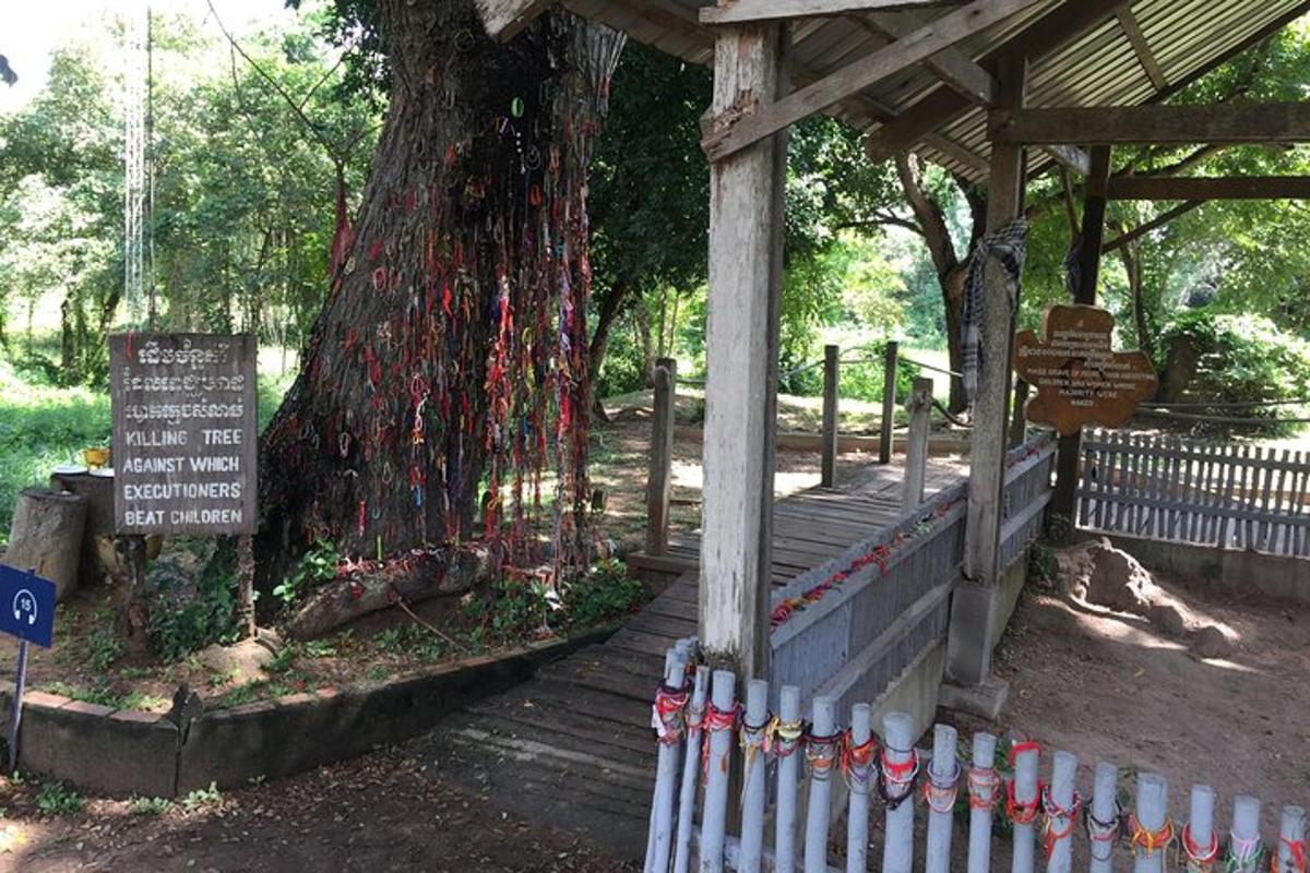 Una valla alrededor de un árbol con una cinta roja alrededor.
