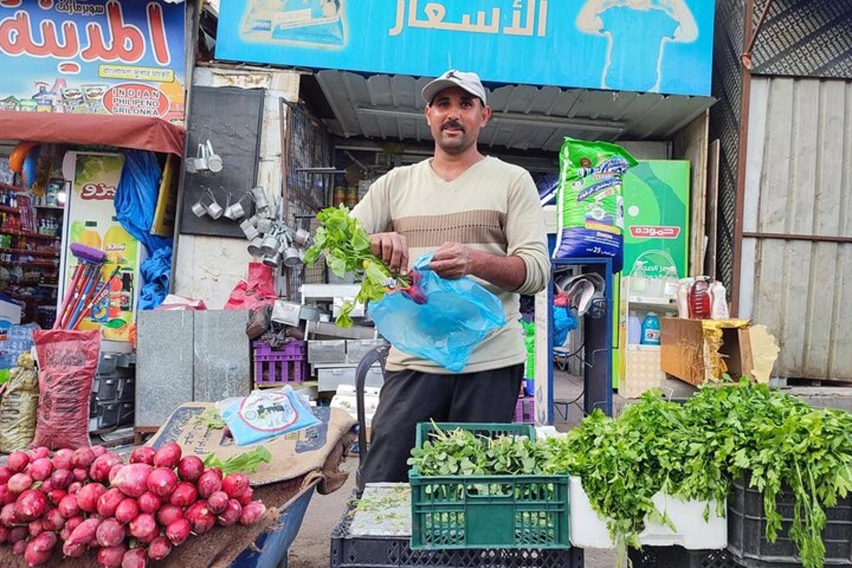 a man standing in front of a market with vegetables