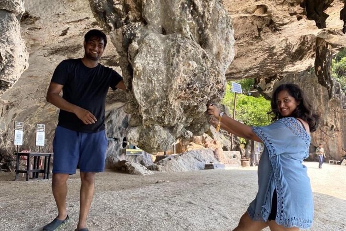 un uomo e una donna in piedi davanti a una roccia