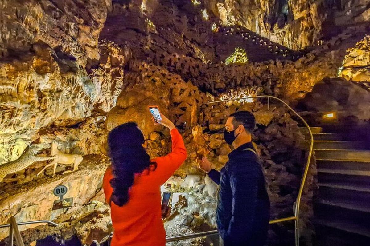 a man and a woman taking a picture in a cave