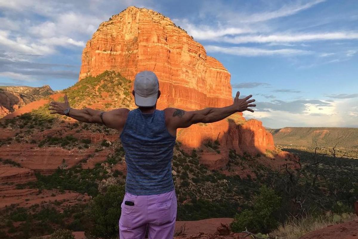 un uomo in piedi sulla cima di una montagna con le braccia tese