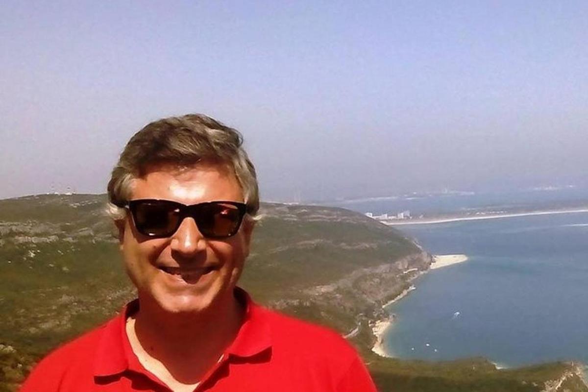 muž se slunečními brýlemi stojící u oceánu