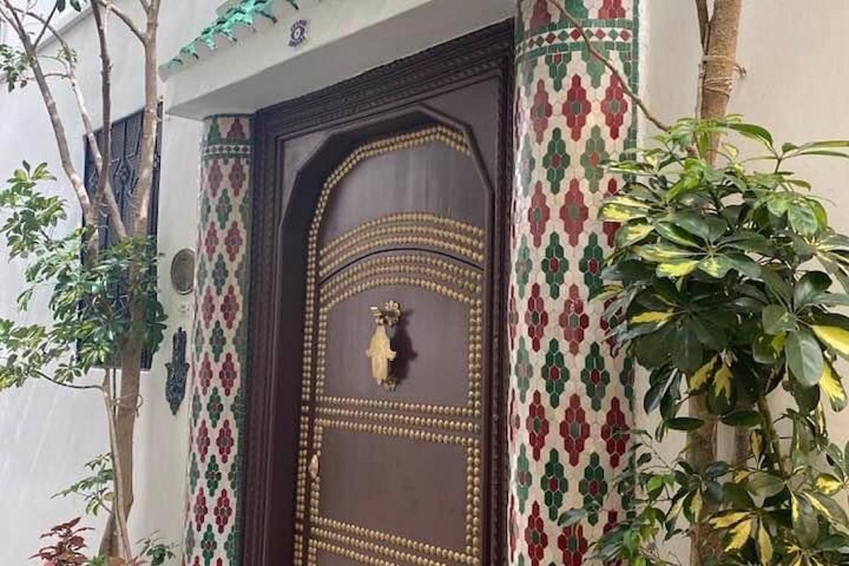 una porta marrone con una statua sopra accanto a una pianta