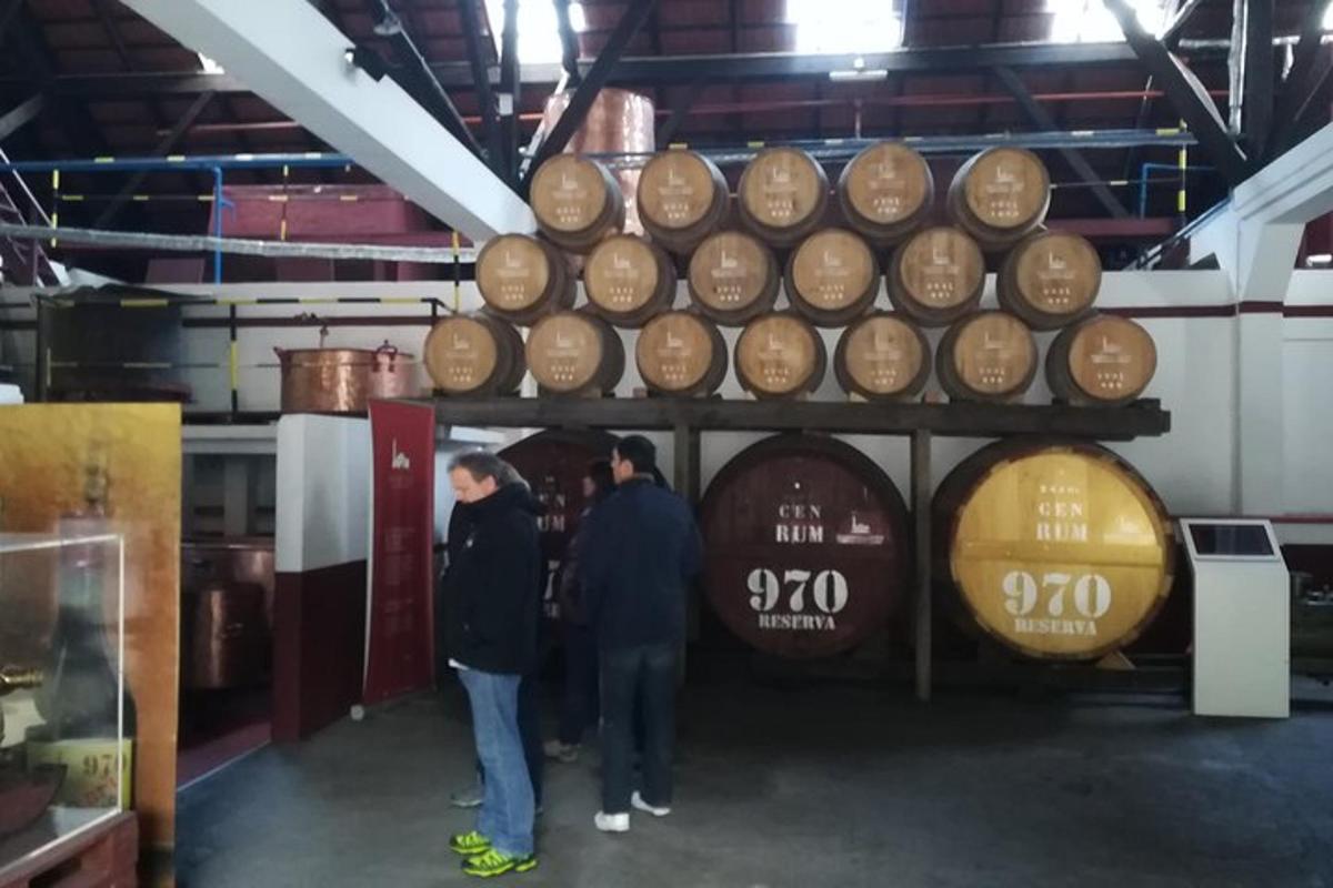 dues persones dempeus davant d'una gran pila de barrils