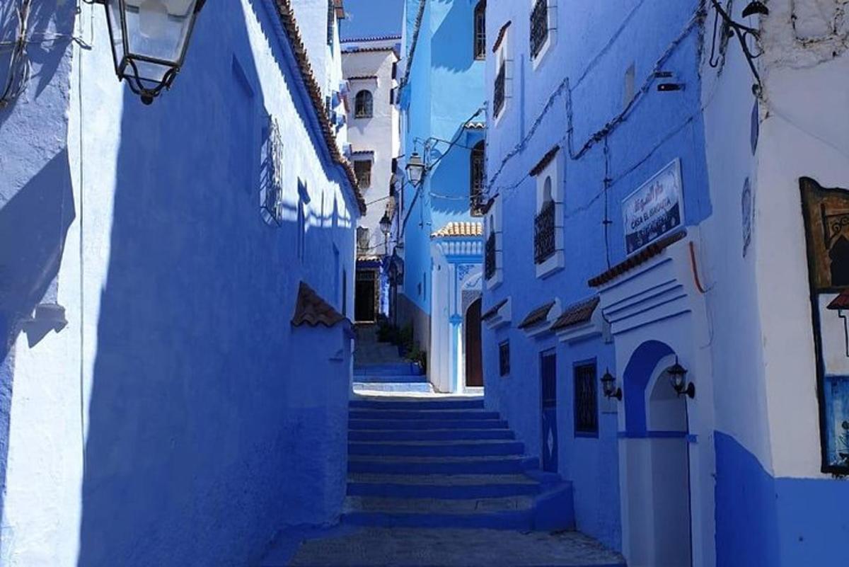un vicolo con muri blu e scale in una città