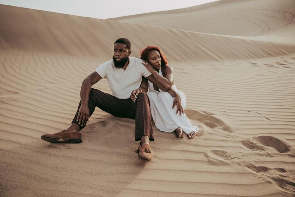 Una novia y un novio sentados en el desierto