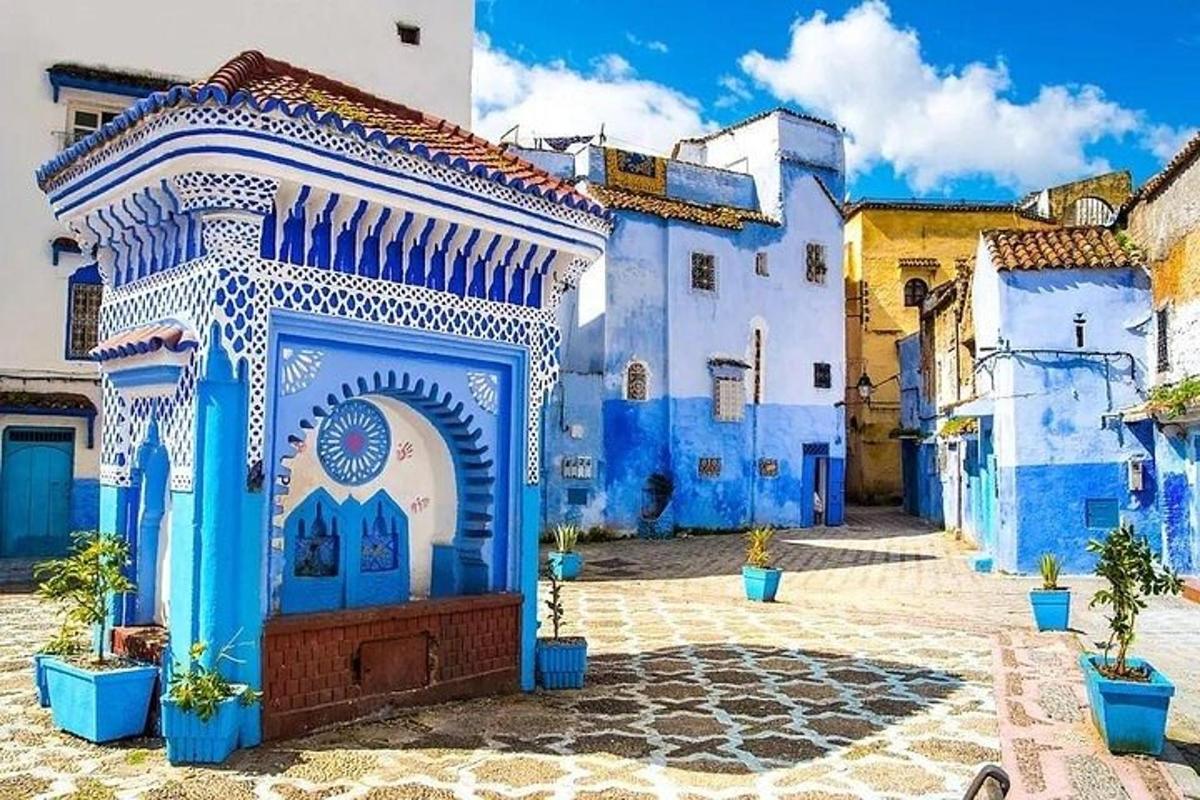 un edifici blau i blanc amb un arc en un pati