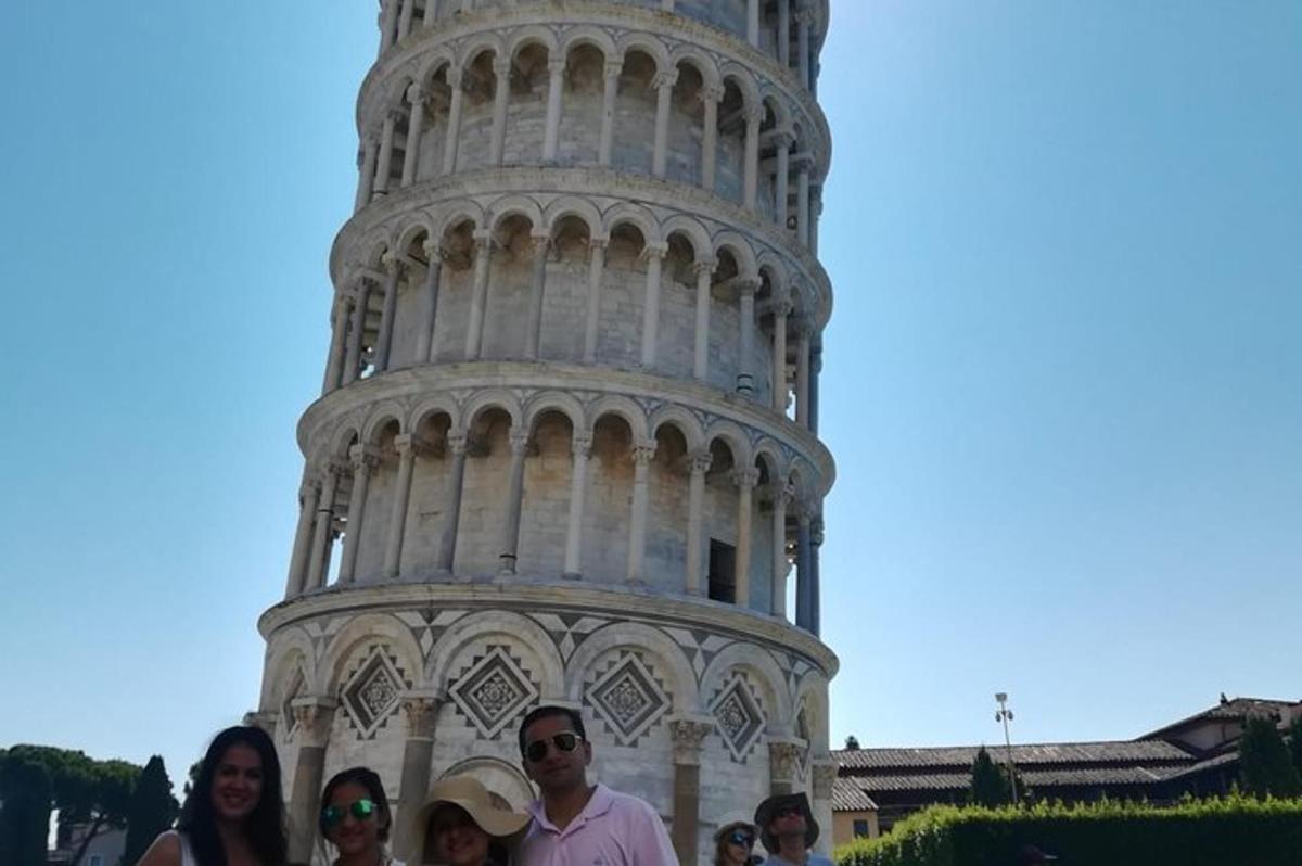 un gruppo di persone in piedi davanti alla torre pendente