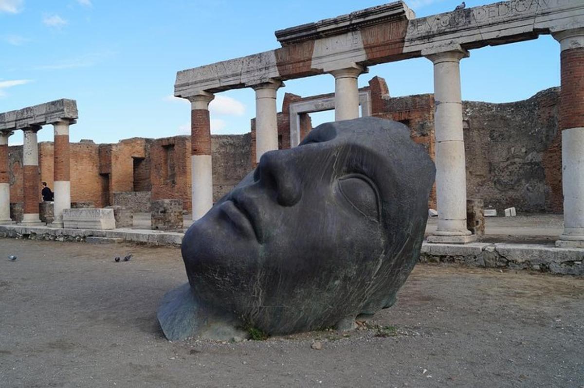 una statua di un volto di fronte a un edificio