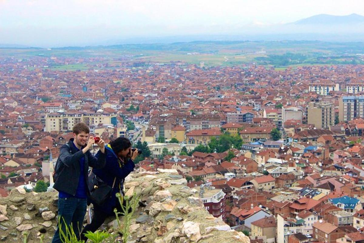 due uomini che scattano foto di una città da una montagna
