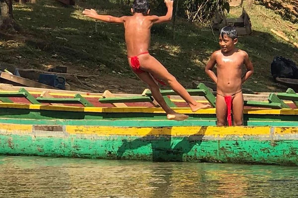 dva mladí chlapci stojící na lodi ve vodě