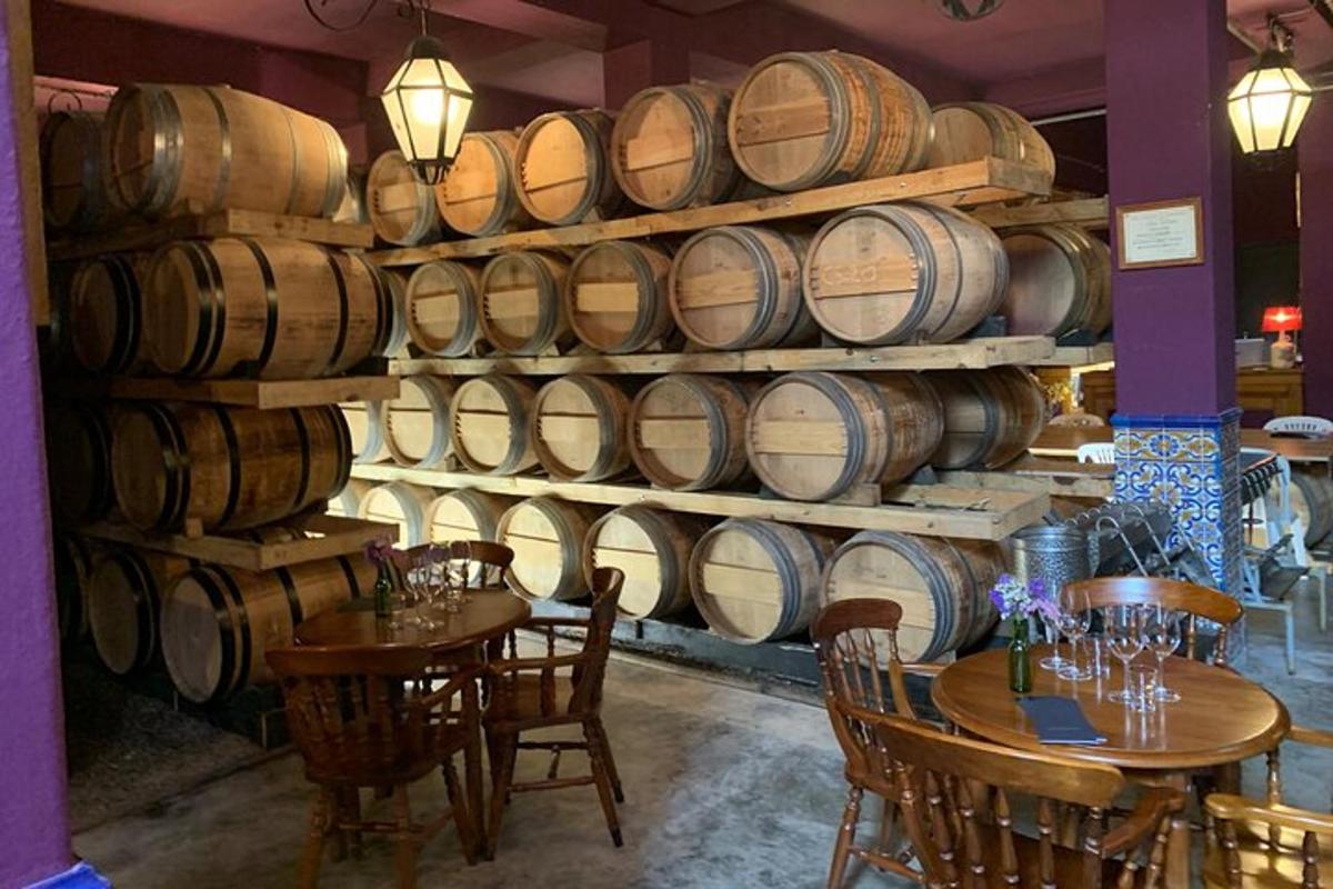 una stanza con tavoli e una grande pila di botti di vino