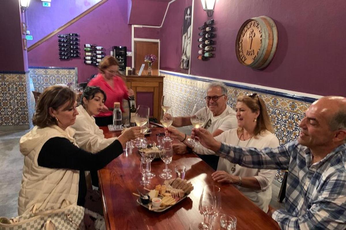 un gruppo di persone sedute attorno a un tavolo con bicchieri di vino