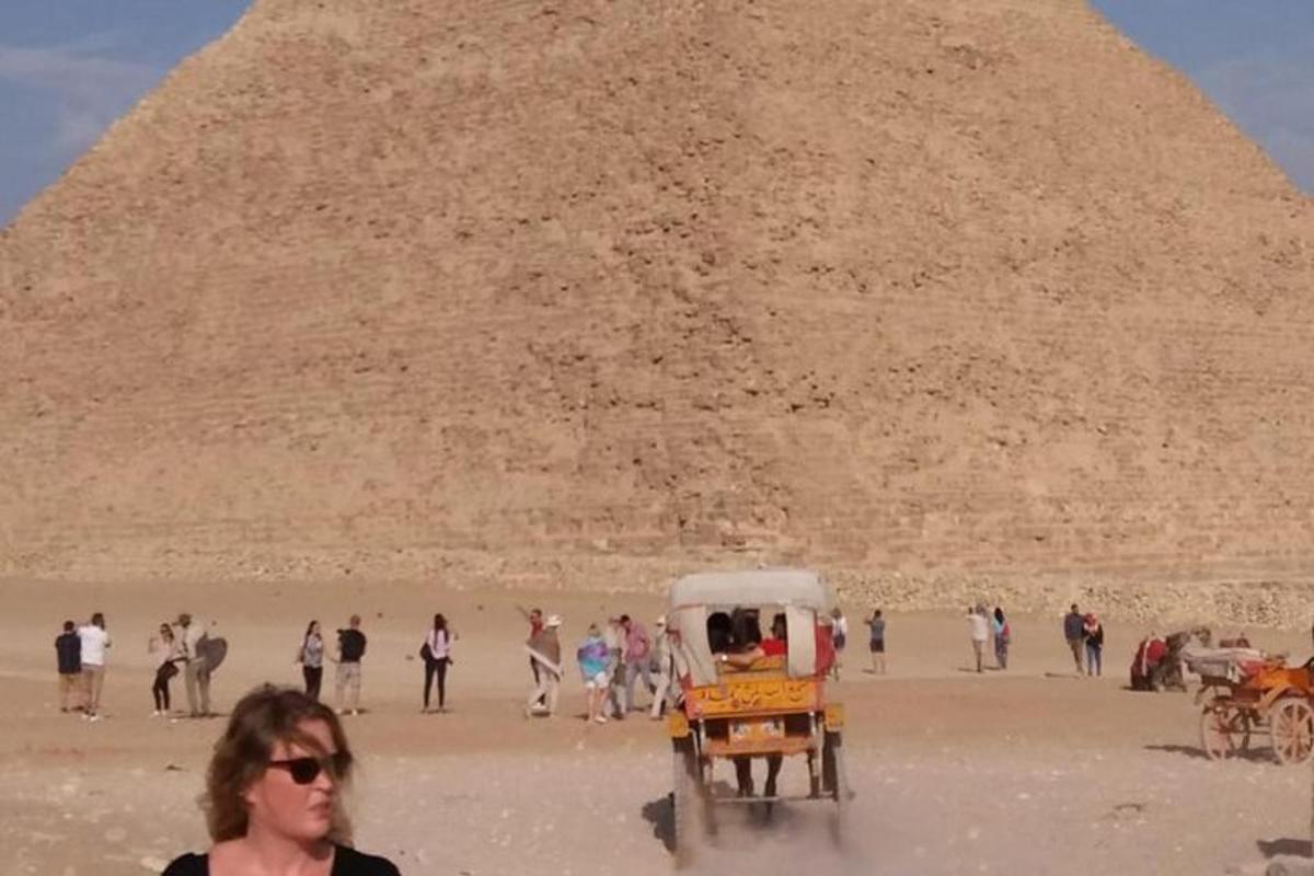 skupina lidí stojící před pyramidou