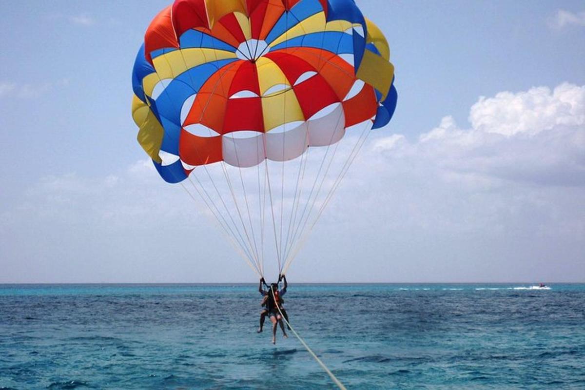 una persona che vola con il paracadute sopra l'oceano