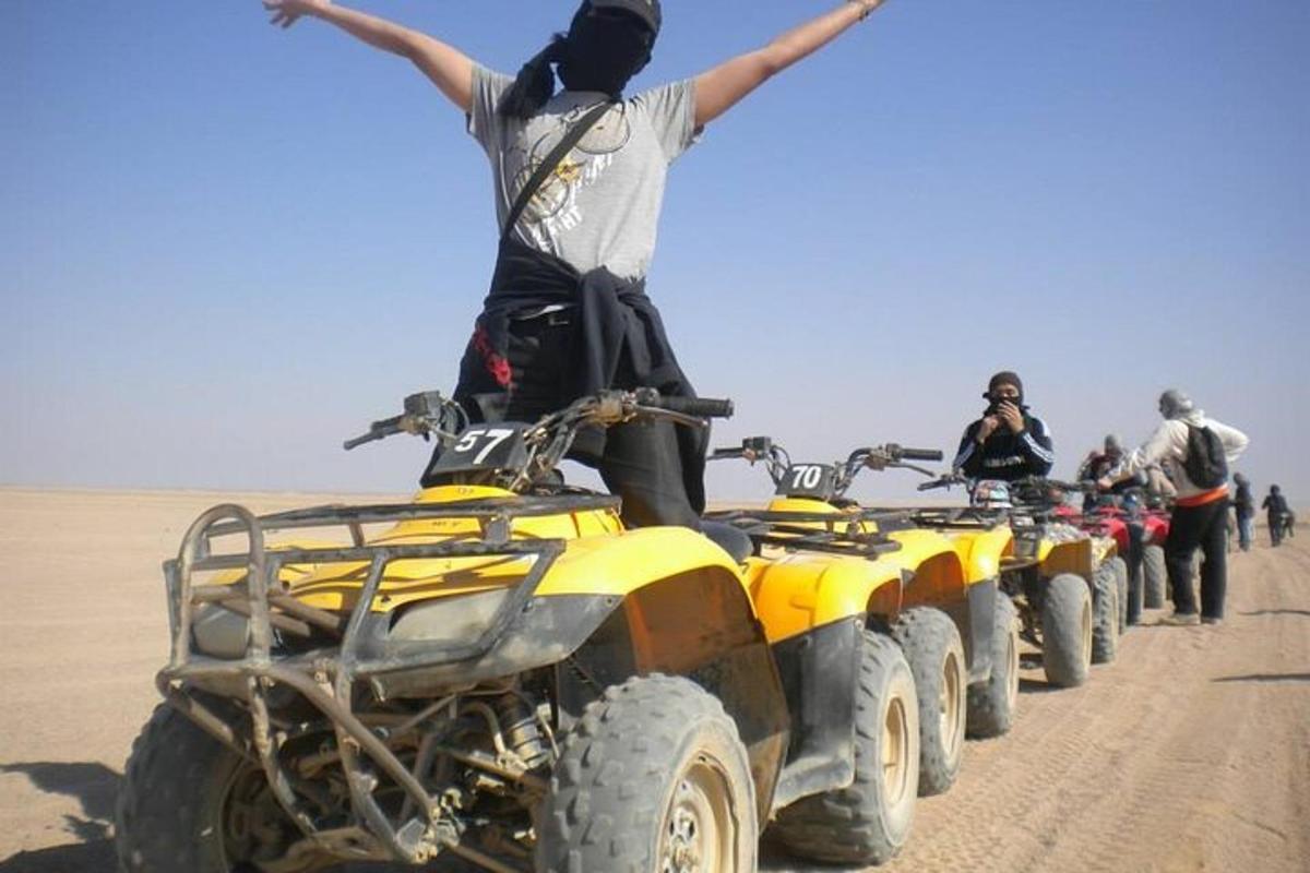 un uomo in piedi su una fila di quad nel deserto
