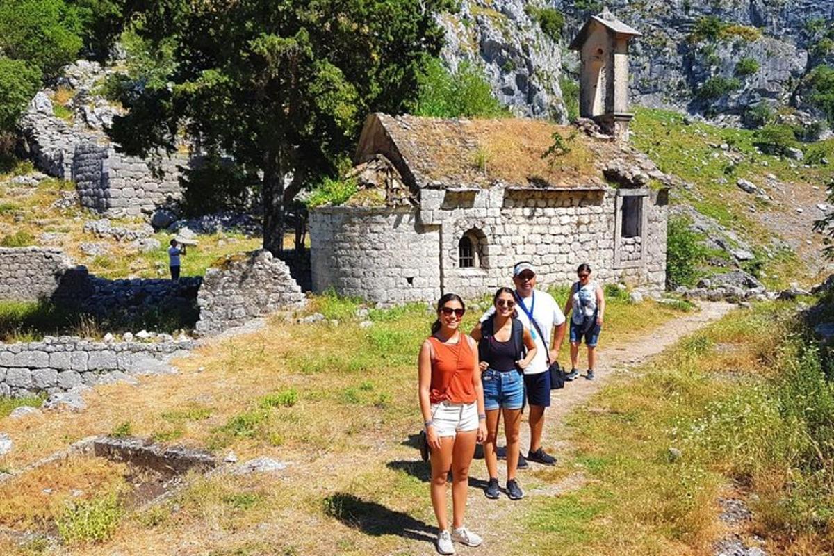 un gruppo di persone in piedi davanti a un edificio in pietra