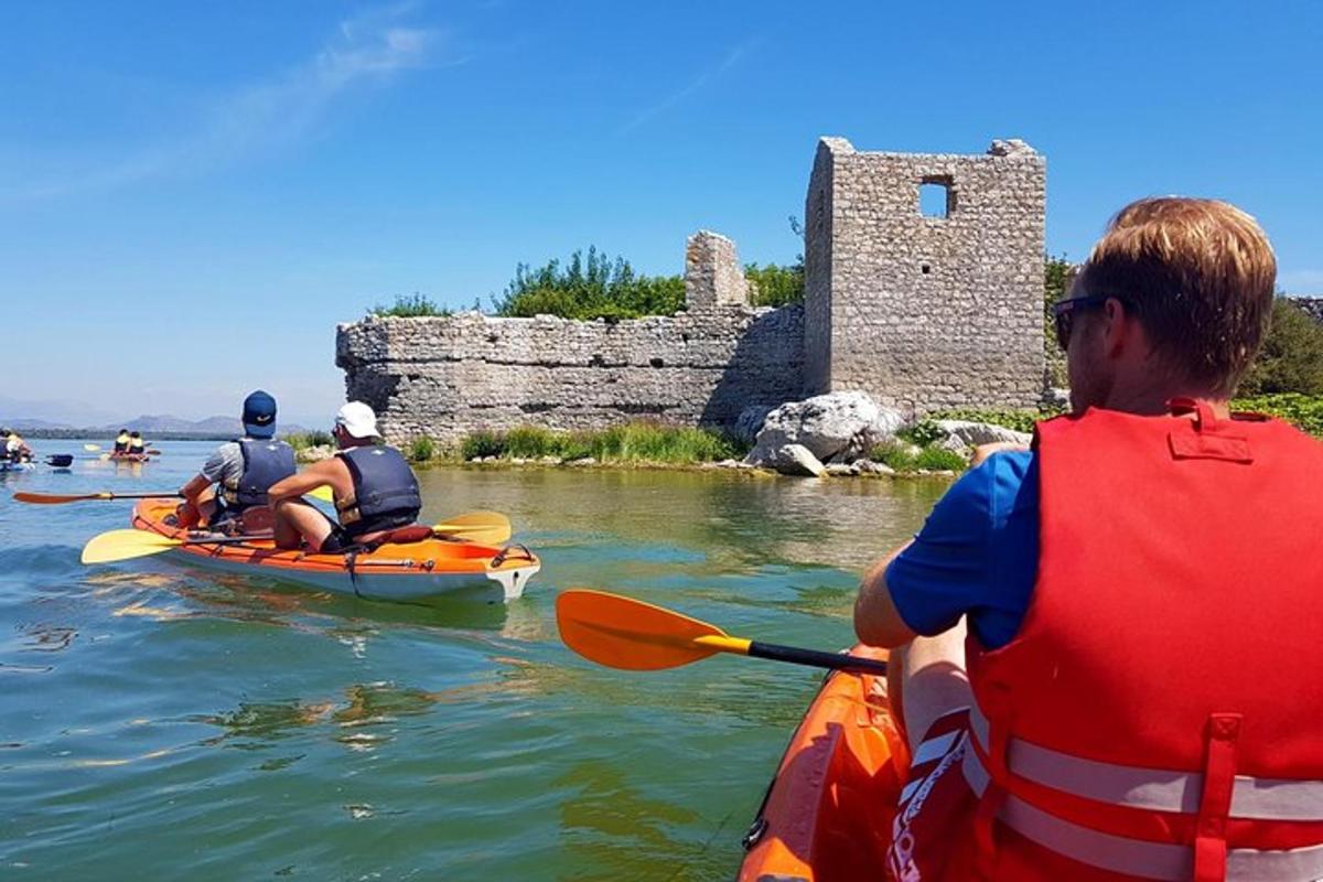 um grupo de pessoas andando de caiaque na água perto de um castelo