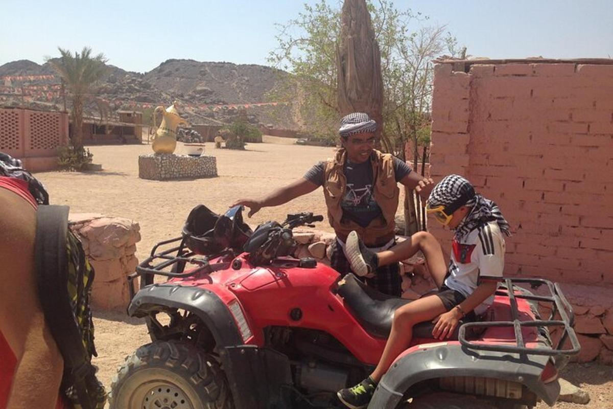 un home i un noi asseguts en un quad