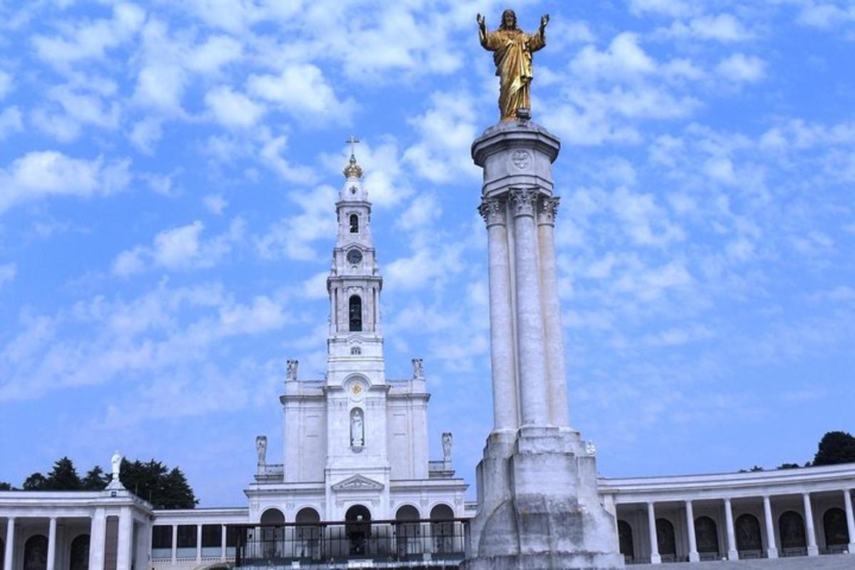 uma estátua no topo de um edifício com uma torre