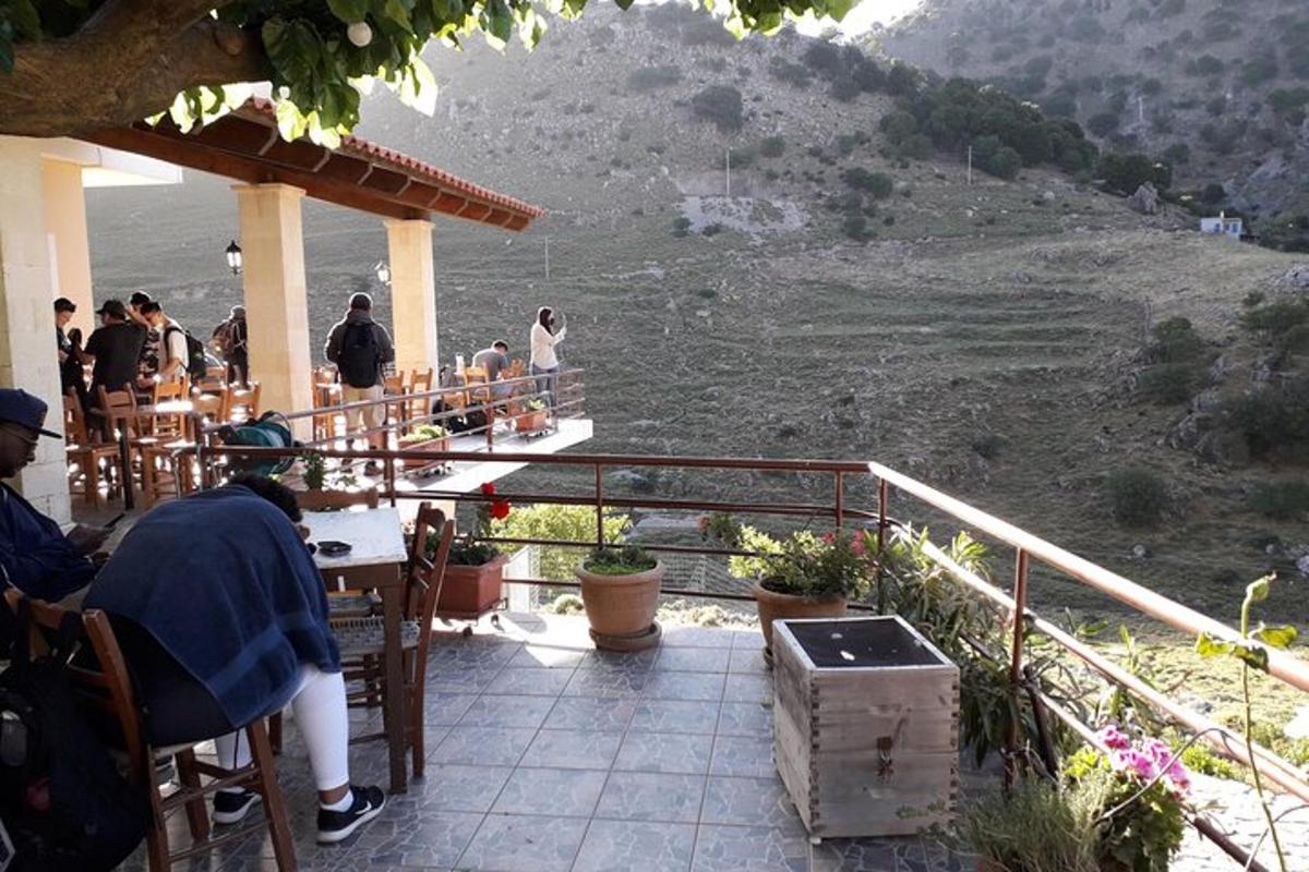 en gruppe mennesker som sitter ved et bord på en terrasse