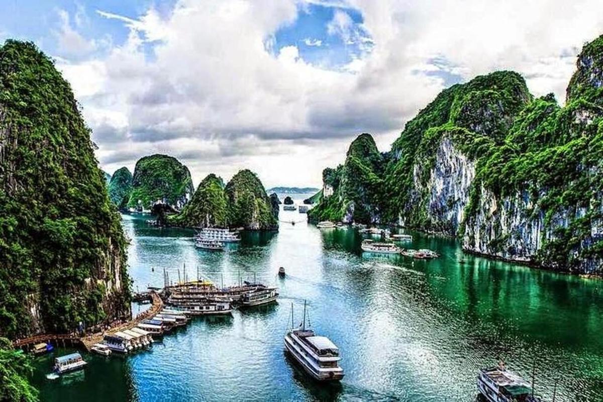 a river with many boats in the water with mountains