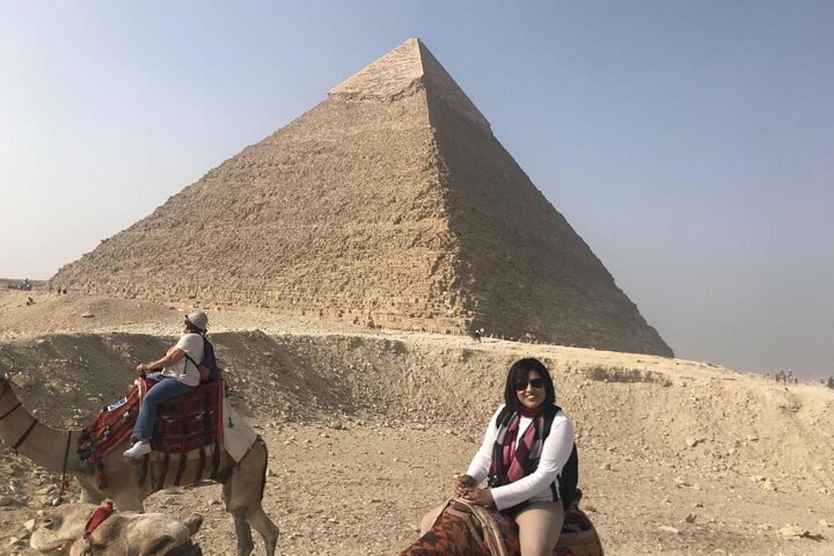 شخصان يركبان الجمال أمام الأهرامات