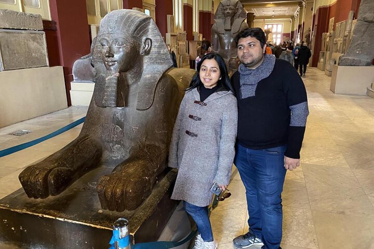 un uomo e una donna in piedi accanto a una statua