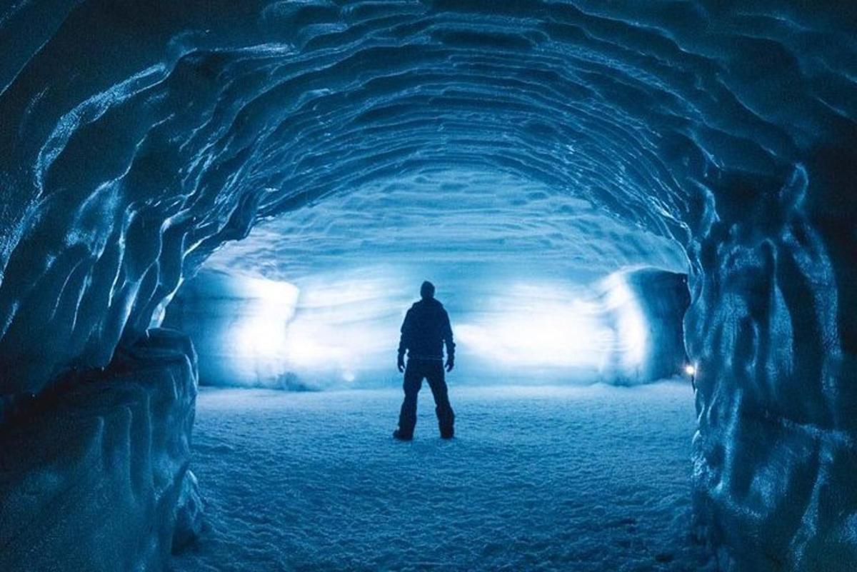 Čovjek stoji u tunelu u ledenoj pećini