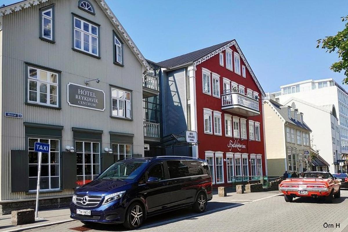 bíll lagður á götu fyrir framan byggingar