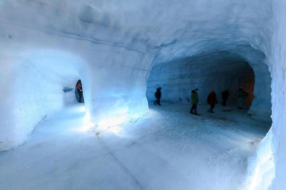 um grupo de pessoas caminhando por um túnel de neve