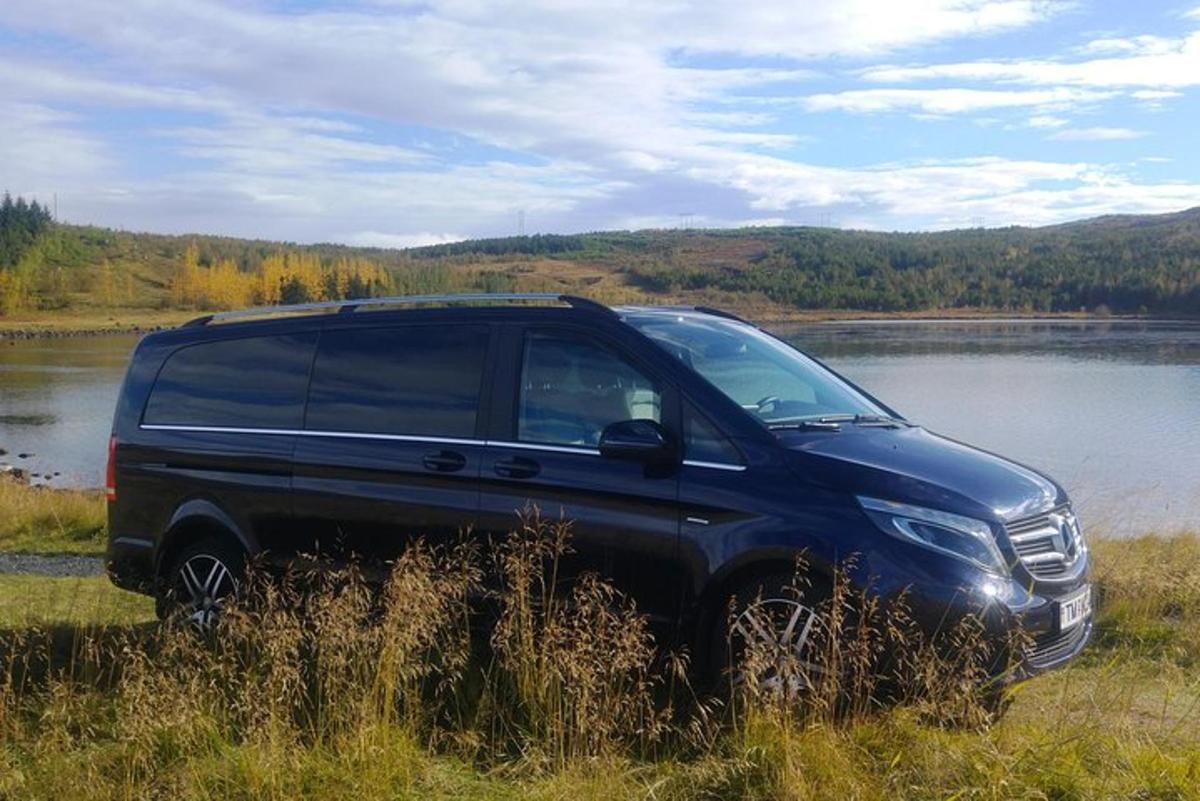 un tot terreny negre aparcat en un camp al costat d'un llac