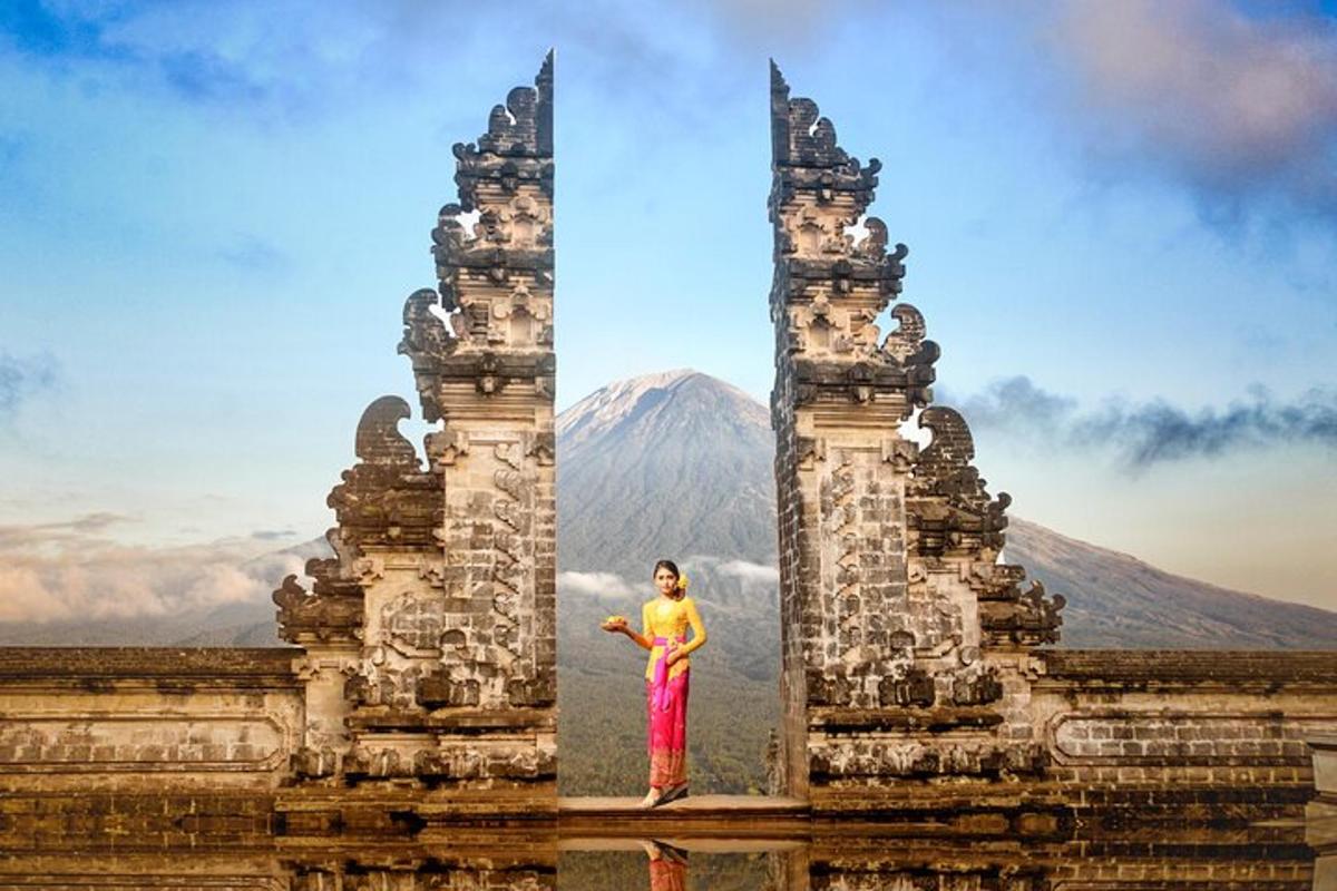seorang wanita berdiri di antara dua menara dengan latar belakang gunung