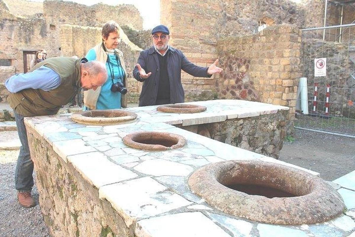 un grup de persones dretes al voltant d'una taula de pedra