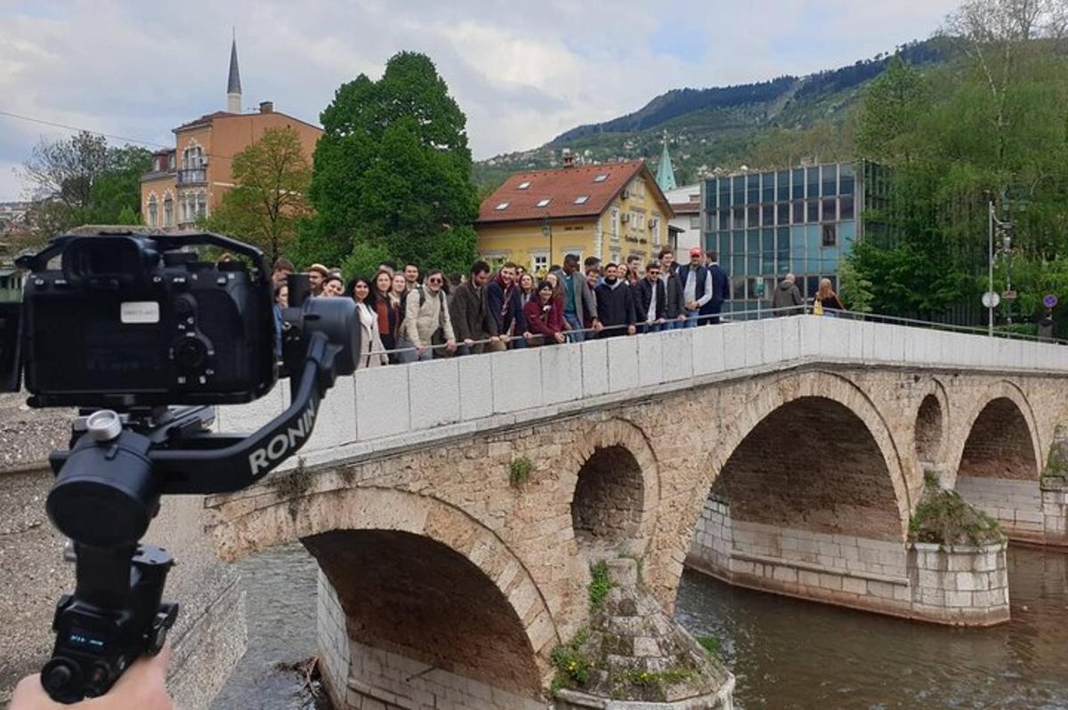 hópur fólks sem fer yfir brú yfir ána
