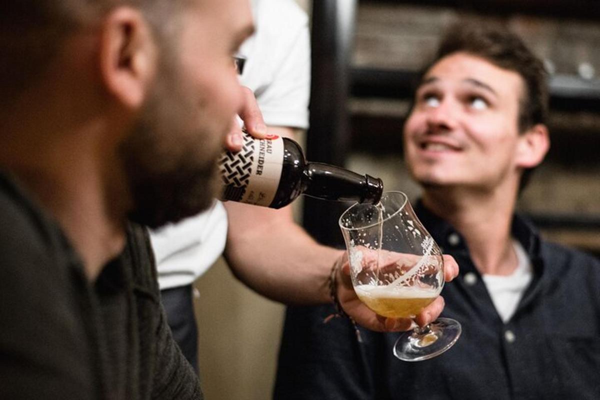 a man pouring a drink into a wine glass