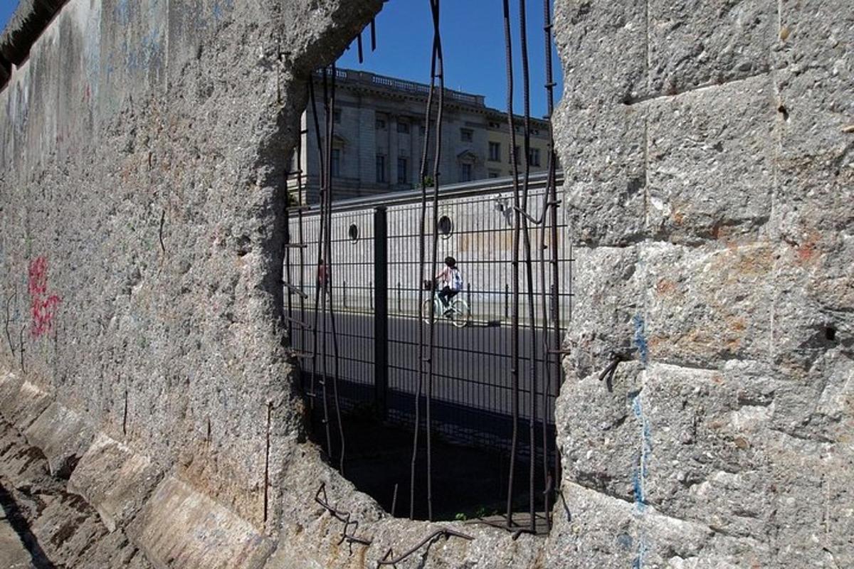 ένα άτομο που περπατά μέσα από μια πύλη σε έναν πέτρινο τοίχο