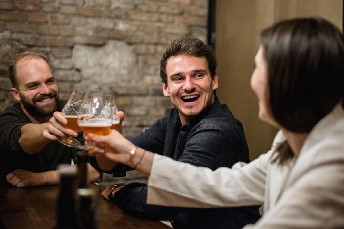 a group of people sitting around a table holding a glass of beer